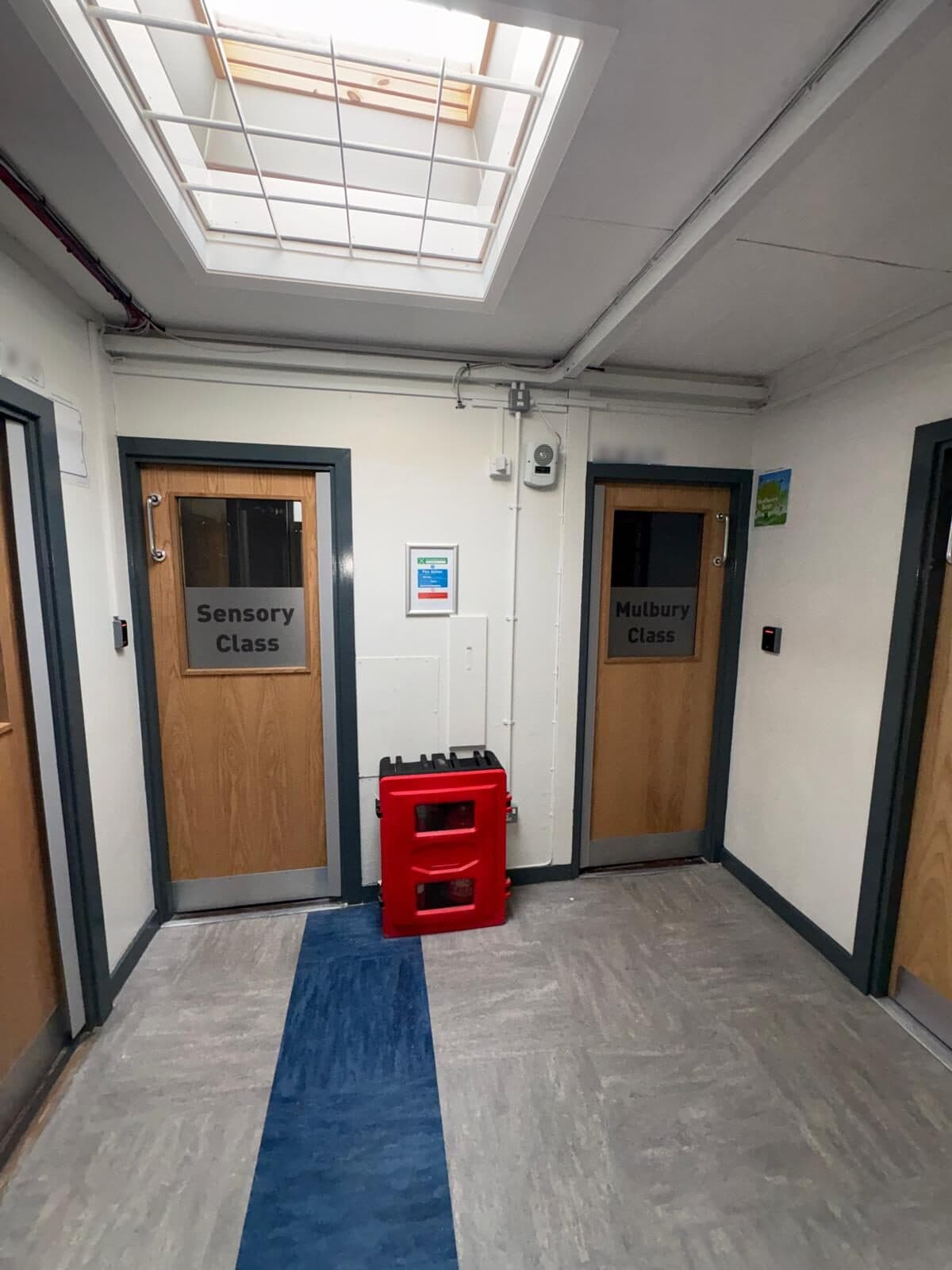 Two new oak-effect fire doors with vision panels in a school corridor in Knowsley, fitted by Marlborough Builders
