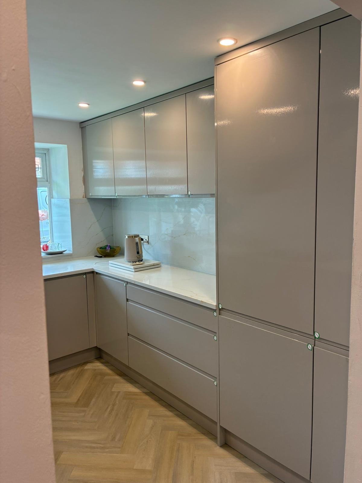Fitted kitchen with handleless cupboards and worktops
